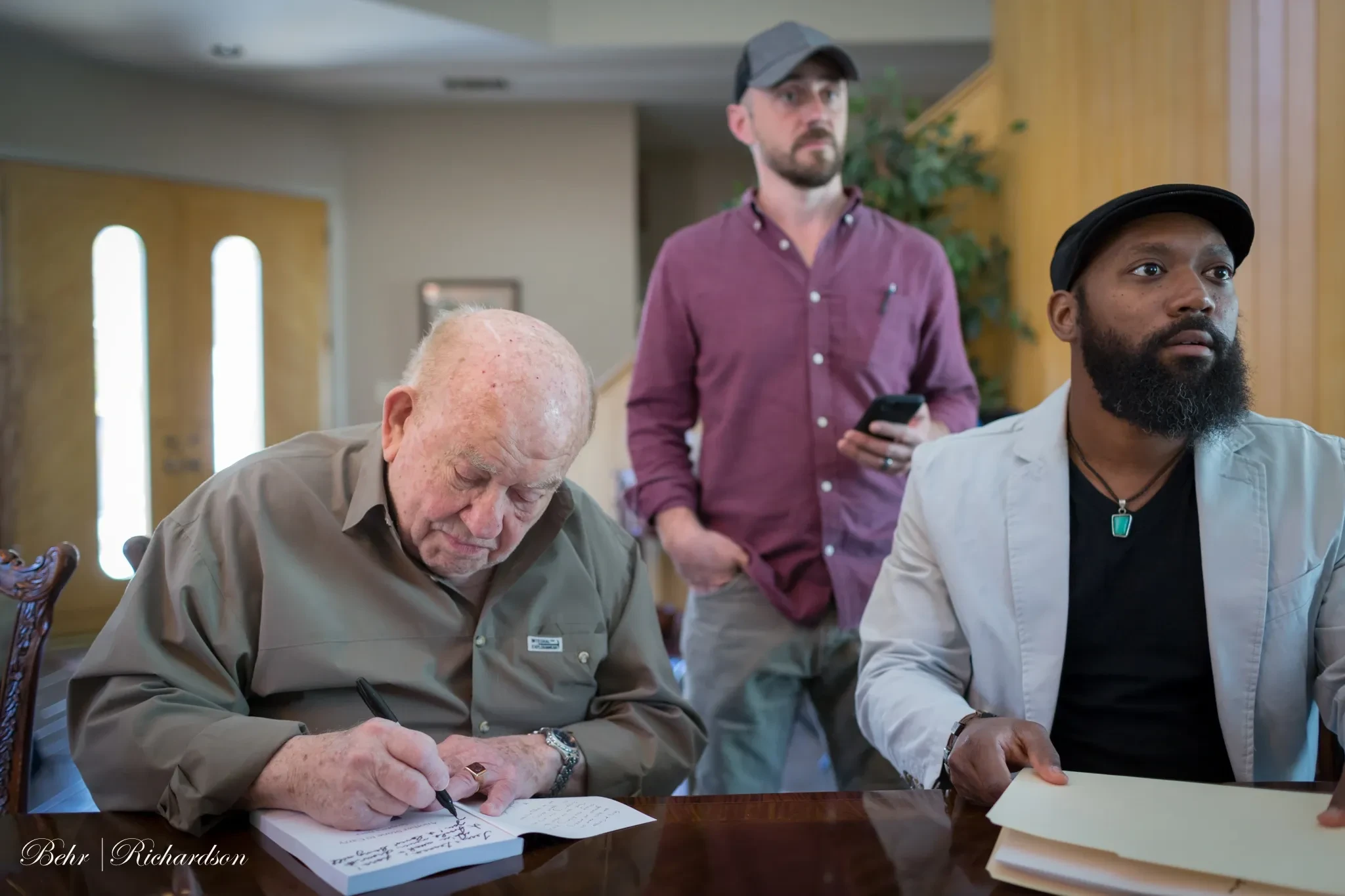 Three men in indoor meeting room scene