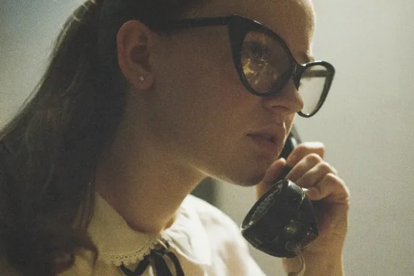 Close-up of a woman with glasses speaking on a telephone in The Vast of Night