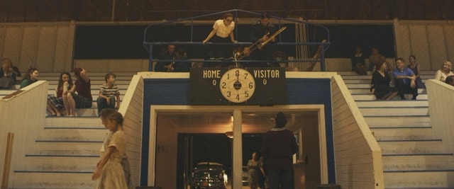 Scoreboard and crowd at a vintage gymnasium basketball game