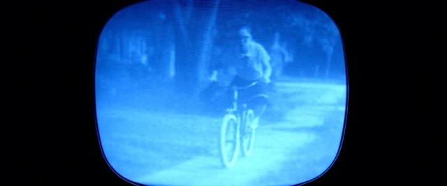 Cyclist seen through a glowing blue vintage television screen